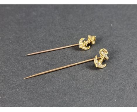 A yellow metal stick pin, with diamond set anchor terminal, 57mm; together with another similar set split pearls, 51mm. (2) 