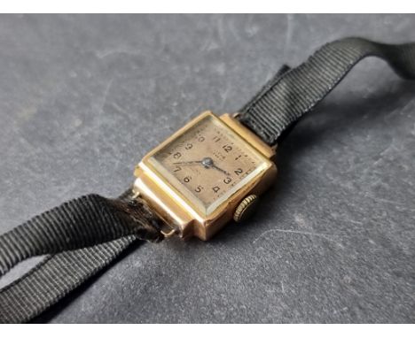 A vintage Titus yellow metal ladies manual wind wristwatch, 15 x 21mm, stamped 18k, on black fabric strap. 
