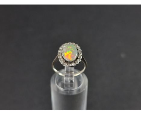 A white metal opal and diamond cluster ring, stamped 18ct, size J. 