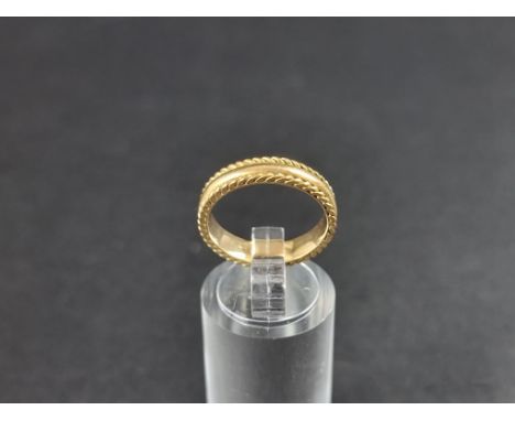 A yellow metal wedding band, stamped 18c, size M. 