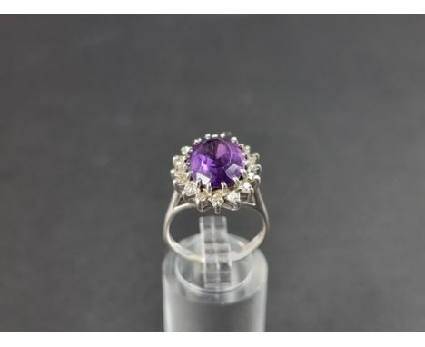 An 18ct gold and amethyst and diamond cluster ring, size M 1/2. 