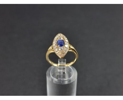 An Edwardian marquise shaped diamond and sapphire cluster ring, set a central facetted sapphire surrounded by twenty mine cut