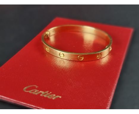 A Cartier 'LOVE' bracelet, with screw motif design, stamped '750', size 17, No.YT5654, complete with screwdriver, Cartier cer