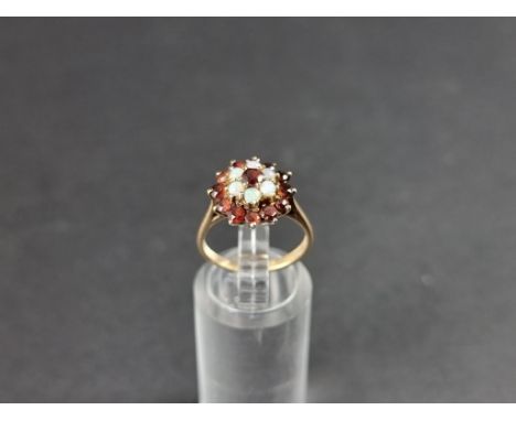 A yellow metal garnet and opal cluster ring, stamped 9ct, size K. 
