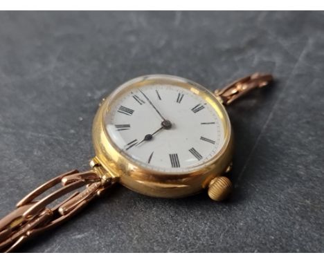 A vintage yellow metal ladies manual wind wristwatch, stamped 18k, 29mm, on an expanding bracelet marked 9ct. 