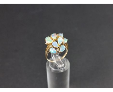 A 9ct gold opal ring, set ten tear drop opals interspersed with four brilliant cut diamonds, size O 1/2. 