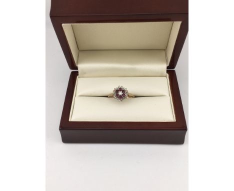 A 9ct diamond and ruby cluster ring. Approx weight 2.14 grams, Approx size N 1/2.