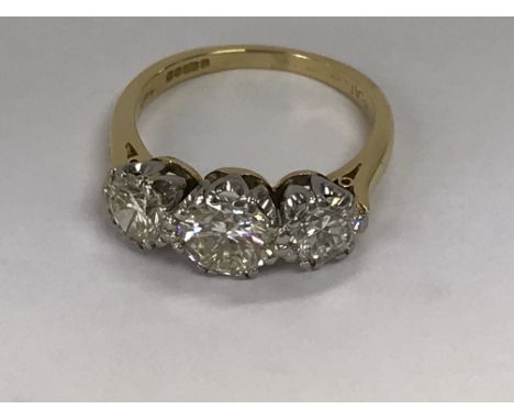 A 18 ct gold ring inset with three brilliant cut diamonds the centre diamond approximately 1.5ct flanked by two further diamo