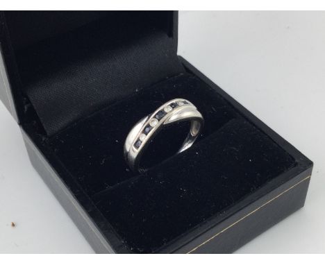 A 9ct white gold almond and sapphire crossover ring. Size L.