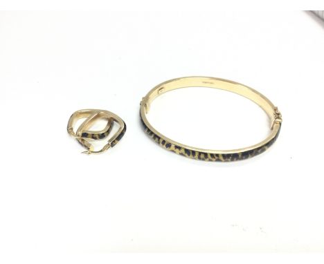 A set of 9ct gold leopard print hoops and bangle. Approx weight 10.38 grams.
