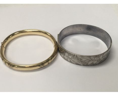 A silver bangle and gold plated bangle.