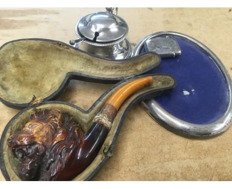 A silver vesta , a pipe in the form of a lionâ€™s head . Together with a small oval photo frame and a silver Cruet .