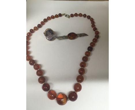 A gold Quartz ring a silver brooch inset with amber and a amber colour Necklace,