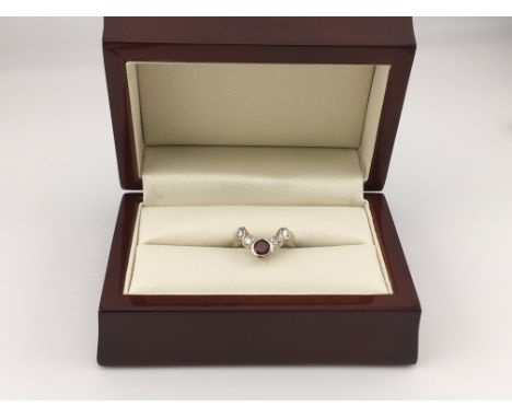 A 14ct white gold diamond and ruby wishbone style ring. Approx weight 3.75 grams, Approx size I1/2.