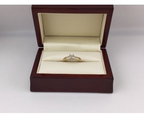 An 18ct gold diamond set ring with a central setting and diamonds set on both shoulder. Approx weight 3.73 grams, approx size