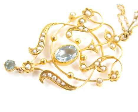 An Edwardian 9ct gold peridot and seed pearl pendant, centred with an oval stone and set with an arrangement of scrolls and f