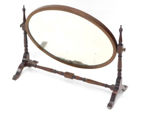 A mahogany dressing table mirror, with oval plate on shaped supports, 64cm wide.