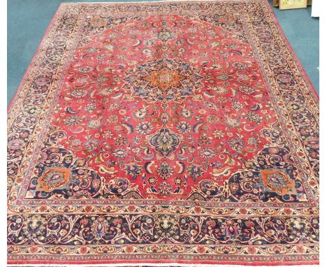 A large Persian Mashed carpet, with red ground and floral medallion, 384cm x 305cm.  