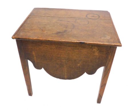 A late 18thC/early 19thC oak box commode, the hinged lid with a ceramic insert above a shaped apron, on square tapering legs,