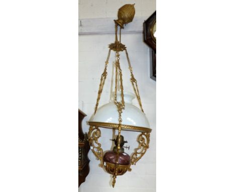 A Victorian gilt metal and glass rise and fall ceiling oil lamp with shade; a champ levee table lamp