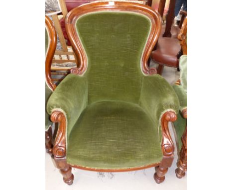 A Victorian mahogany spoon back armchair with scrolled arm terminals and turned legs, in green dralon