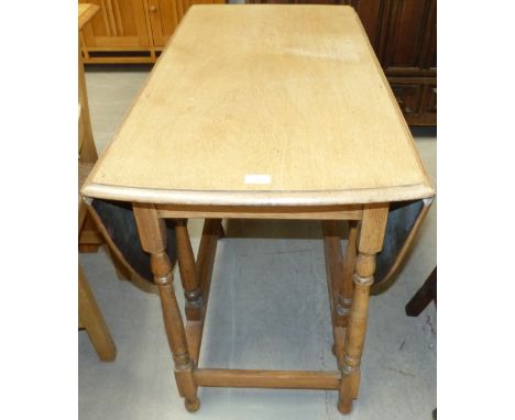 A 1920's oak oval gate leg drop leaf dining table, 42"