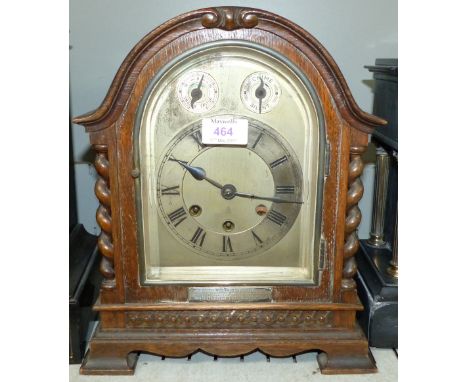An early 20th century arch top mantel clock in oak case, with silvered dial and Westminster chiming movement