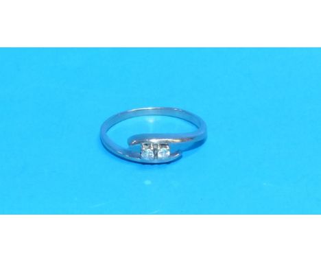 A small modern white metal dress ring stamped '585' set with 2 small diamonds in crossover mount (stones approximately 0.03 c