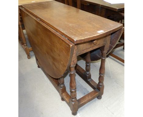 A Jacobean style heavy oak oval gate leg drop leaf table, 53"