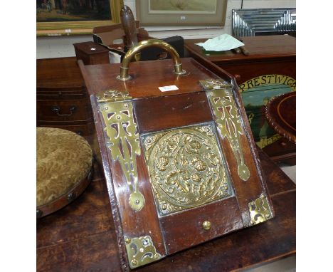 An Edwardian walnut slope front coal box with brass hinges and embossed panel