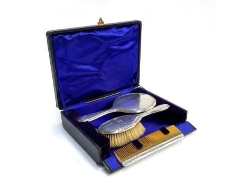 A cased Edwardian vanity set comprising silver cased mirror, brush and comb, hallmarked for Birmingham, 1910