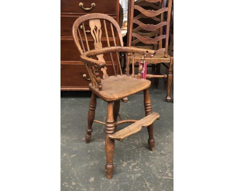 An ash and elm child's Windsor highchair, ring turned legs joined by crinoline stretcher, the seat 49cmH