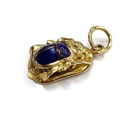 An Egyptian gold and lapis scarab beetle pendant, tests as 14ct or higher, hallmarked on jump ring, 1.9cmL, 1.4g