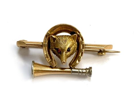 A late Victorian gold brooch in the form of a fox mask, horseshoe and hunting horn, set with red cabochon eyes, 3cm wide, 6.3