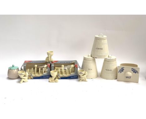 Two Lurpak toast racks together with four eggcups; a set of three enamel coffee/tea/sugar canisters; a ceramic salt cellar an