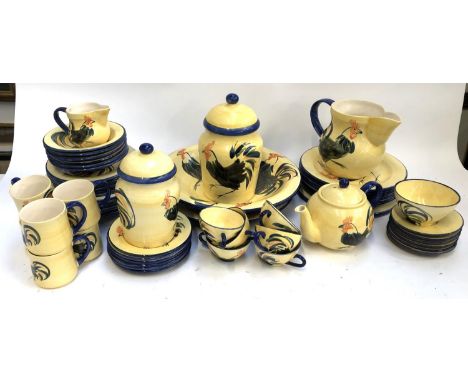 A Suzanne Katkhuda part dinner and tea service with cockerel decoration on a yellow glaze, for six settings, to include teapo