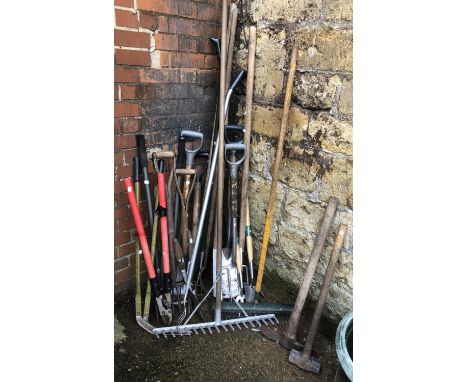A quantity of vintage garden tools to include pickaxe, rakes, forks, spade, sledgehammer, trowels, etc