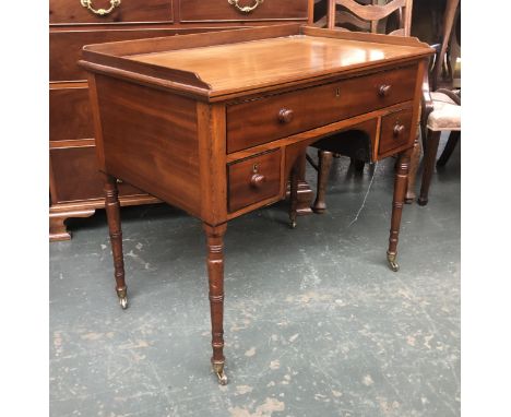 A Regency mahogany kneehole dressing table, three quarter gallery over three drawers, on tapering ring turn legs, 92x56x79cm