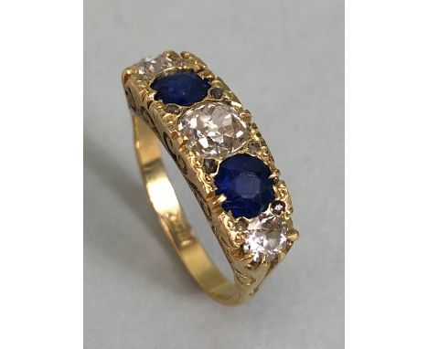 A sapphire and diamond boat shaped ring, with three Diamonds and two faceted Sapphire stones (A/F), the central diamond appro