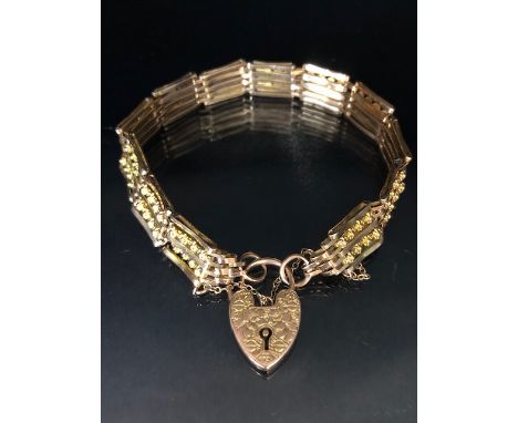 Unusual gate style bracelet in 9ct Gold with 9ct heart shaped lock the gate design of alternate bars and Gold daisy style flo