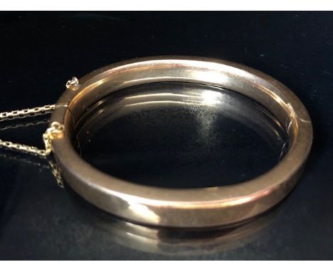 Unmarked Gold bangle approx 65mm across with safety chain total weight approx 18.5g