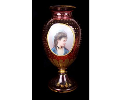 A Bohemain ruby glass vase with portrait medallion of a young girl, the ruby glass gilded overall with star motifs, ovoid for