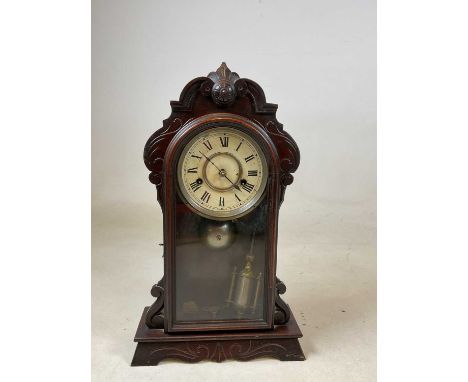 A late 19th century American 'gingerbread' mantel clock, the circular dial set with Roman numerals, height 45cm.