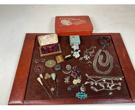 A quantity of costume jewellery including a bangle, brooches, cased studs, etc, all contained within a tin.