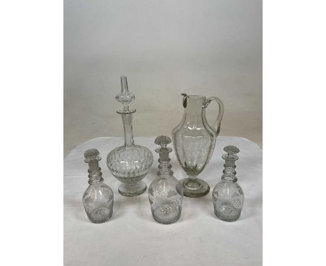 19th century glassware comprising three matching decanters with engraved grapes and vine and a pitcher with engraved ferns an