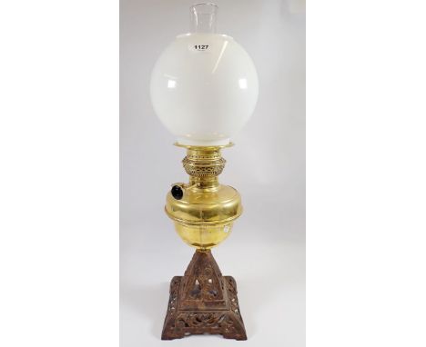 A Victorian brass and iron oil lamp with opaque globe shade 