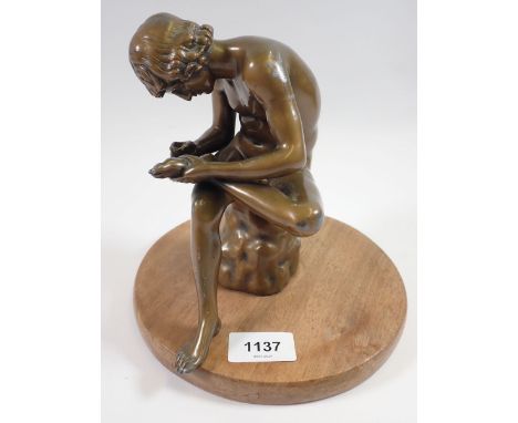 A bronze finish figure of man removing thorn from his foot on later base, 19cm tall 