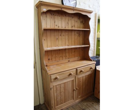 A solid pine modern shelf back dresser with two doors and two drawers