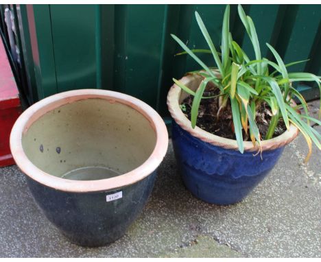 A dark blue terracotta pot and a light blue painted pot, one with plant