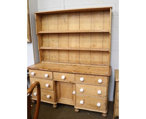 A Victorian Pine Reverse Breakfront Kitchen Dresser, with enclosed waterfall three shelf rack, pot drawer pulls and on turned